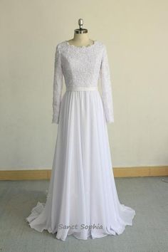 a white wedding dress on a mannequin in front of a wall and floor