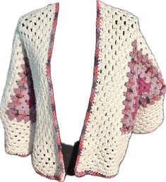 a white crocheted shawl with pink flowers on it