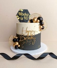 a black and white birthday cake with gold decorations