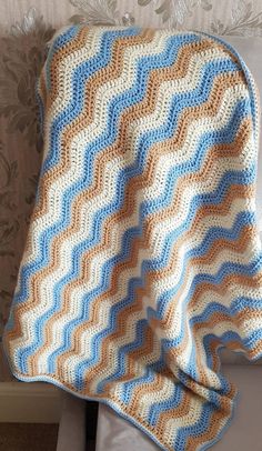 a crocheted blanket sitting on top of a bed