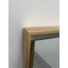 a gold framed mirror against a white wall