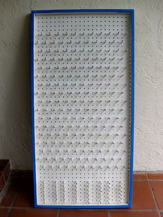 a white and blue frame sitting on top of a tile floor next to a wall