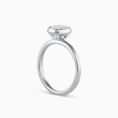 The Tulip Engagement Ring combines modern elegance and timeless design. This ring is a bezel setting that sits taller allowing for straight bands to sit flush. The Tulip Engagement Ring can be set with any size or shape of center stone and is available in 14k or 18k yellow gold, white gold, rose gold or platinum. The price listed includes the setting only. Want more info? Book an appointment to sit down with one of our bridal experts virtually or in-store. Timeless Bezel-set Diamond Promise Ring, Timeless Bezel Set Diamond Promise Ring, Timeless Diamond Promise Ring With Bezel Setting, Timeless Solitaire Halo Ring With Round Band, Timeless Diamond Ring With Bezel Setting, Timeless Diamond Ring With Bezel Setting For Promise, Timeless Asscher Cut Diamond Ring With Bezel Setting, Classic Halo Ring In White Gold With Bezel Setting, Modern Solitaire Stackable Rings For Promise