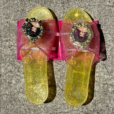 a pair of yellow and pink flip flops with an image of a woman's face on them