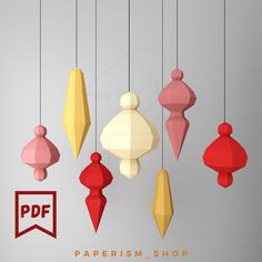 several different colored wooden ornaments hanging from strings with the word paperism shop below them