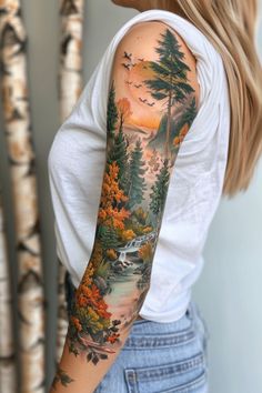 a woman's arm with a forest scene on it