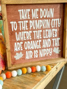 a wooden sign that says take me down to the pumpkin city where the leaves are orange and the air is nippy