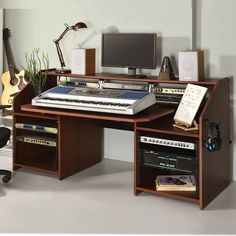 a computer desk with a keyboard, monitor and other musical equipment on top of it