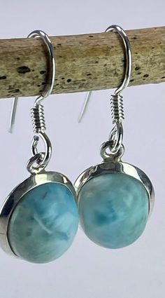 A distinctive and eye-catching pair of Dominican Larimar and silver drop earrings. This stone is a good size and is of a tranquil, blue coral colour Larimar, oval-cut and set in the classic half-bezel.  Measurements  - 1.4cm long x 1.1cm wide and 0.7cm deep. Drop - 3.0 cm Weight - 5 grams (2.5 grams per earring) About the stone: Larimar is the embodiment of the tranquil Sea and Sky energies. Its soft, soothing blues and calming turquoise is streaked with white patterns that resemble sunlight dan Coral Colour, Tranquil Blue, Half Bezel, Blue Coral, Silver Dangle Earrings, Coral Blue, Ancient Wisdom, Silver Drop Earrings, Healing Powers