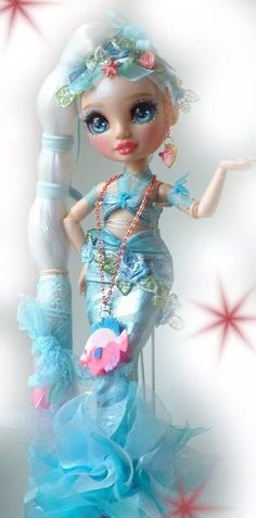 the doll is wearing a blue dress with flowers on it