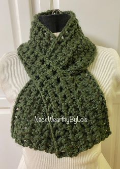 a green crocheted scarf on top of a mannequin