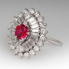 This stunning vintage ring is crafted of platinum and features a orangey red ruby surrounded by baguette and round diamonds. The ruby is rich and vibrant, and is completely natural and unheated. The diamonds are all high quality and eye clean. The ring is currently a size 6.5 and we offer complimentary resizing to fit. Red Diamond Ring With Baguette Cut, Red Ruby Ring With Baguette Diamonds, Red Ruby Ring With Baguette Cut Center Stone, Red Diamond Platinum Ring, Red Ruby Ring With Halo Setting In Platinum, Red Baguette Cut Diamond Ring, Red Baguette Cut Lab-created Ruby Ring, Red Baguette Diamond Wedding Rings, Fine Jewelry Red Baguette Cut Ruby Ring