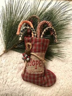 a christmas stocking hanging from the side of a pine tree with candy canes in it