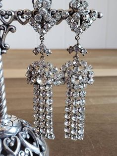 This is a vintage, set of clip on earrings. They are metal with clear faceted rhinestones. These measure a bit over 3 inches in length. Don't forget to stop in at my other Etsy shop... http://www.etsy.com/shop/xtdesigns. Follow me on Twitter at... MyYiayiaHadThat@MyYiayiaHadThat. If you have a wish list or are looking for something specific, please ask. I may have exactly what you are looking for. As always please convo me with any questions or concerns regarding this item or with any internatio Vintage Metal Crystal Earrings For Wedding, Silver Vintage Clip-on Earrings For Vintage Events, Vintage Metal Dangle Crystal Earrings, Vintage Metal Crystal Earrings, Vintage Crystal Earrings For Wedding, Vintage Jeweled Metal Clip-on Earrings, Vintage Silver Jeweled Clip-on Earrings, Vintage Metal Crystal Earrings For Party, Vintage Clip-on Crystal Earrings For Wedding