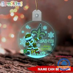 a new orleans saints ornament hanging on a christmas tree with lights in the background