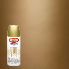 krylon metallic spray paint in gold on a brown background with a white chair