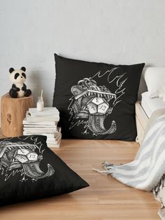 two black pillows sitting on top of a wooden floor next to a stuffed panda bear