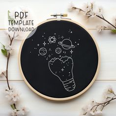 a black and white embroidery pattern with an image of a hand holding a light bulb