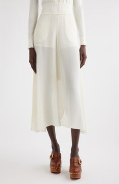 From the Chloé season of flowy comes this pair of semisheer silk culottes cut with high-low hems that slant from knee-length inseams to calf-grazing outseams. Side-seam pockets Semisheer Partially lined 100% silk Dry clean Imported Designer Clothing This brand has B Corp certification, representing business practices with emphasis on social and environmental performance, accountability and transparency This brand meets Nordstrom Responsible Brands criteria: brand adheres to responsible social an Knee-length Bottoms For Summer Evening, Elegant Flowy Skirt With Handkerchief Hem, Formal Bottoms With Asymmetrical Hem, Knee-length Bottoms For Spring Evening, Chic Summer Culottes With Flowy Skirt, Chic Flowy Culottes For Summer, Chic Summer Culottes With Flowy Fit, Elegant White Bottoms With Asymmetrical Hem, Summer Sheer Asymmetrical Skirt