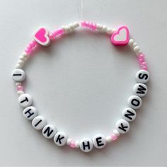 a pink and white beaded bracelet with words that say i love you, think he knows