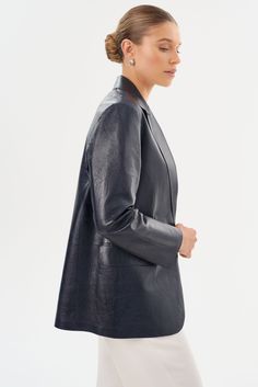 Laissez-vous séduire par l'élégance intemporelle du blazer en cuir QUIRINA, un ajout essentiel à toute garde-robe distinguée. Conçu avec un col à pointe et orné de poches à rabat classiques, ce blazer dégage sophistication et polyvalence. Sa construction non doublée garantit une sensation de légèreté, idéale pour traverser les saisons de transition avec aisance. Associez-le facilement avec un jean et un tee-shirt pour un ensemble discret mais chic, ou adoptez une allure professionnelle raffinée