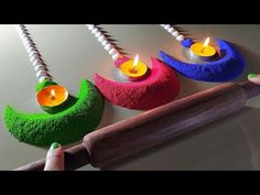 three colorful candles sitting on top of a wooden stick