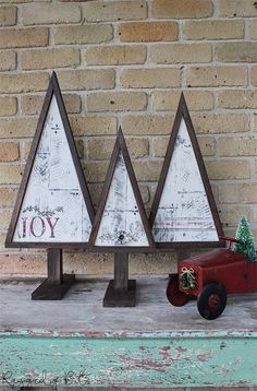 three wooden christmas trees sitting on top of a shelf