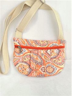 "Peachy Paisley Print Small Zip Purse. Cross Body Quilted Mini Purse, , Hands Free Pouch, Travel Cross Body Purse, Quilted Zipper Phone Pouch has soft pleats on the front. This hip pouch opens with a zipper across the front and has an inside pocket.  It's click buckle adjustable cotton web strapping that will fit most average size waists.   It can be used as a hands free travel purse or cell phone pouch.  Great for outfits that have no pockets.  Handy hands free pouch for shopping, dog walking, hiking, cycling, etc. It is handmade of fully quilted exterior and lining.  It can be hand washed and laid out flat to dry.   Your size should be in the middle range to provide for comfort adjusting.  Easily put on and off with a click buckle.    Overview:   *  Size: 9\" across the top and 7\" tall Cheap Pouch With Adjustable Strap, Cheap Everyday Use Pouch With Wrist Strap, Cheap Crossbody Pouch For Gifts, Cheap Pouch With Wrist Strap, Cheap Zipper Crossbody Pouch, Cheap Rectangular Pouch With Wrist Strap, Cheap Festival Bags With Zipper Pocket, Cheap Crossbody Pouch With Removable Section, Affordable Pouch Bag With Functional Pockets