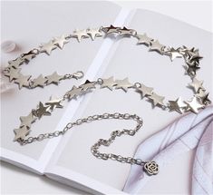 Starry metal chain belt with a rose charm extension. Will fit most sizes because it can be hooked on any part with a jump ring. 28" length of stars, 12" length of extension Trendy Silver Chain Belt As Gift, Trendy Metal Waist Chain Gift, Trendy Metal Waist Chain As Gift, Trendy Metal Waist Chain Perfect As A Gift, Trendy Adjustable Chain Belt As Gift, Metal Chain Belt For Gifts, Trendy Silver Metal Chain Belt, Metal Chain Belt As Gift, Metal Chain Link Belt For Gift