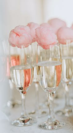 wine glasses filled with pink cotton balls on top of each other and lined up in rows