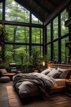 a bedroom with large windows and lots of natural greenery in the room, along with a bed that's surrounded by wooden flooring