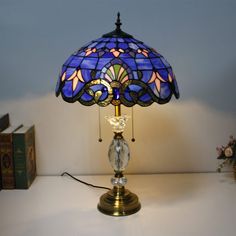 a lamp that is on top of a table next to some books and a book