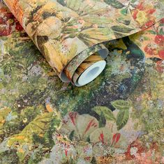 an artistic wallpaper with colorful flowers and leaves on it's surface, including a roll of tape