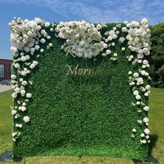 a green wall with white flowers and the word mom written on it