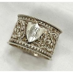 an ornate silver ring with the initials on it