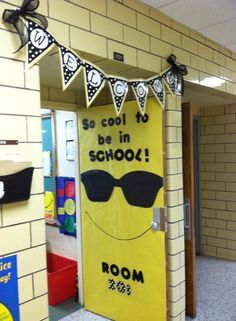 a classroom door decorated to look like a smiley face with sunglasses and the words, so cool to be in school