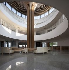 a large circular room with couches and tables in it