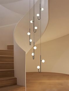 a spiral staircase with several lights hanging from it