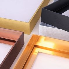 three different colored frames sitting next to each other on top of a white countertop