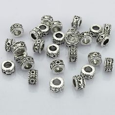 a bunch of silver colored beads on a white surface