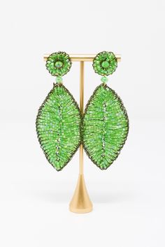 The Lavish by TM Green Leaf Earrings are beautiful addition to any outfit! Material: Enameled wire, hypoallergenic and nickel-freeOrigin: Hand made in Brazil Stud closure Hand crocheted Lightweight 3.5" drop Lavish by Tricia Milaneze is ethereal and lace designs are ideal for women looking for an attractive accessory, but avoiding solid, heavy jewelry. All pieces are extremely feminine, wearable and accessible. Green Metal Beaded Earrings For Party, Green Metal Beaded Party Earrings, Elegant Green Hypoallergenic Beaded Earrings, Green Leaf-shaped Party Jewelry, Heavy Jewelry, Lace Designs, Made In Brazil, Green Leaf, Lace Design