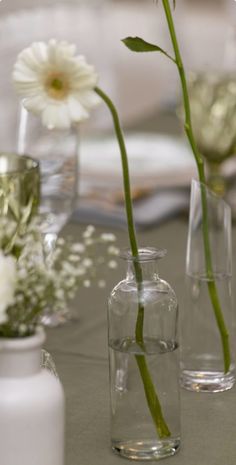 three vases with flowers in them sitting on a table