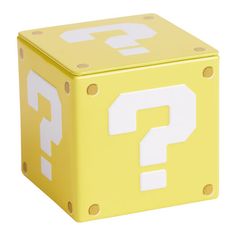 a yellow and white cube with question mark on the front, sitting in front of a white background