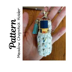 a hand holding a crocheted keychain with a lighter on it