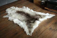 a white and brown animal skin rug on the floor