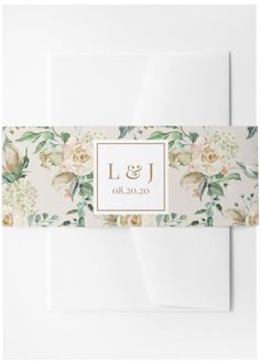 a wedding card with flowers and leaves on the front, in white envelope liners