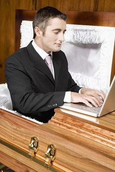 a man in a suit using a laptop computer on a chest with white laces