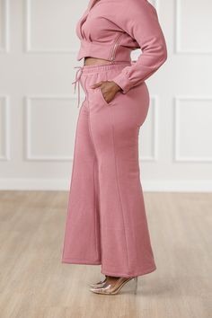 This item is Final Sale. No refunds or exchanges will be honored. A J. Brooks Exclusive! Indulge in a touch of opulence with our Quinnley Seamed Flare Pants. These high-rise pants boast a figure-flattering silhouette, accentuated by elegant piping detail and a graceful flared hem. The fleece lining offers warmth and comfort, making these pants perfect for any occasion. Elevate your wardrobe with these luxurious pants. Description: High rise. Close fit through hips and thighs, and flared at the h Pink Long Pants With Solid Color, Pink Wide Leg Pants With Elastic Waistband For Fall, Pink Wide-leg Loungewear Bottoms, Pink Wide-leg Pants For Loungewear, Pink Full-length Loungewear Bottoms, Pink Loungewear Bottoms With Pockets, Pink Solid Color Loungewear Bottoms, Pink Lounge Bottoms With Pockets, Pink Bottoms With Pockets For Loungewear