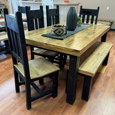 a wooden table with black chairs and a bowl on it's centerpieces