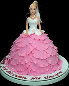 a barbie doll cake with pink and white ruffles